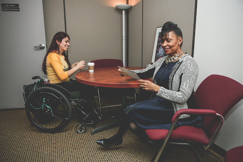Staff member working with student in a wheelchair.